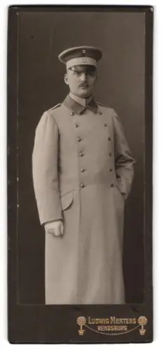 Fotografie Ludwig Mertens, Rendsburg, Am Gymnasium, Leutnant im Uniformmantel mit Schirmmütze