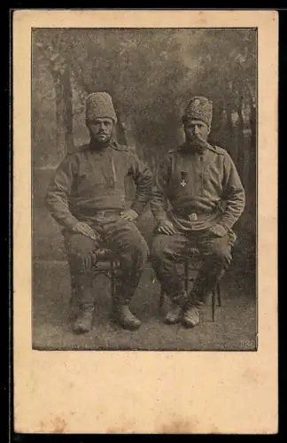 AK Zwei russische Soldaten in Uniform mit Pelzmütze und Ehrenzeichen