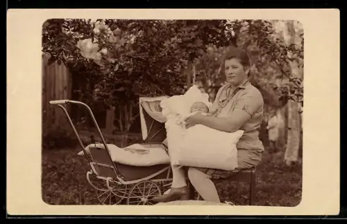 Foto-AK Frau mit Kleinkind und Kinderwagen in einem Garten