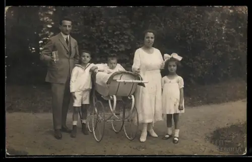 Foto-AK Familie mit drei Kindern u. Kinderwagen in einem Park