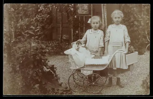 Foto-AK Zwei kleine Mädchen mit Puppe im Kinderwagen auf dem Kiesweg vor einem Haus