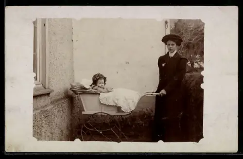 Foto-AK Junge Dame mit Kleinkind im Kinderwagen neben einem Haus