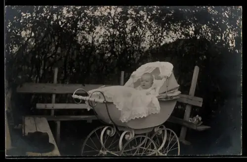 Foto-AK Säugling im Kinderwagen in einem Garten