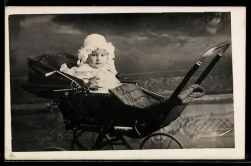 Foto-AK Kleinkind mit Rüschenhaube in einem Kinderwagen