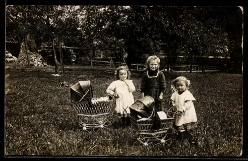 Foto-AK Drei kleine Mädchen mit Kinderwagen in einem Garten