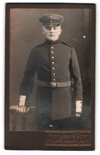 Fotografie Photographie Vogt, Lahr, Marktpl. 22, Soldat in Uniform mit Schirmmütze und Bajonett