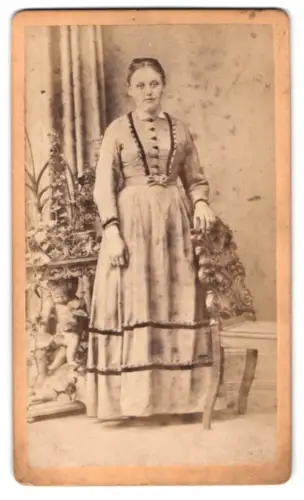 Fotografie Th. Immler, Bregenz, Frau in traditioneller Kleidung neben dekorativem Tisch