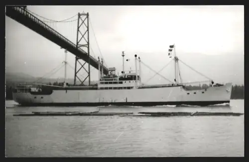Fotografie Norwegisches Frachtschiff Thor I von 1938 passiert eine Hängebrücke