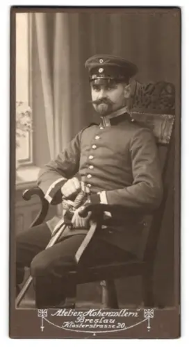 Fotografie Atelier Hohenzollern, Breslau, Klosterstrasse 20, Sergeant in Uniform mit Schirmmütze und Säbel