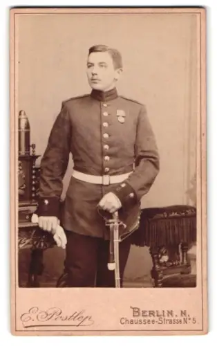 Fotografie Atelier Postlep, Berlin, Chaussee-Strasse 5, Garde-Soldat in Uniform mit KDM 1870/71, Säbel und Granate