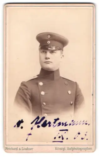 Fotografie Reichard & Lindner, Berlin, Unter den Linden 54/55, Offizier im Uniformmantel mit Schirmmütze, 1903