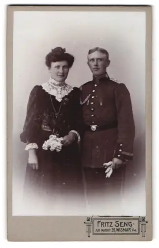 Fotografie Fritz Seng, Wismar i. M., Am Markt 26, Sergeant in Uniform mit Schützenschnur 1. St., Seitenwaffe u. Frau
