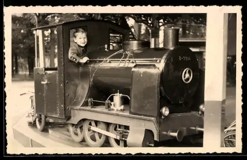Foto-AK Kind in einem Eisenbahnführwagen auf einem Karussell, Volksfest