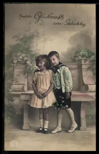 Foto-AK R & K / L Nr. 8819/2: Kleines Paar vor einer Bank, Geburtstagsgruss