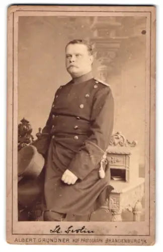Fotografie Albert Grundner, Brandenburg a. H., Haupt-Strasse 42, Offizier im Überock mit Schirmmütze und Seitenwaffe