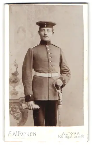 Fotografie A. W. Popken, Altona, Königstrasse 97, Soldat in Uniform mit Krätzchen und Säbel