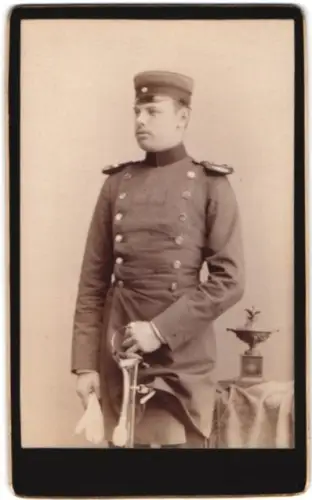 Fotografie Julius Rogall, Lübeck, Beckergrube 9, Offizier im Überrock mit Schirmmütze und Säbel