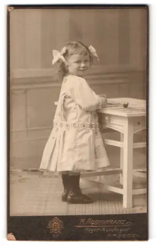 Fotografie R. Rosenkranz, Laubegast b. Dresden, Gust. Hartmannstr. 2, Kleines Mädchen am Tisch