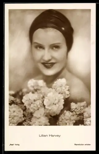 AK Schauspielerin Lilian Harvey mit Kopftuch und Blumen lacht in die Kamera