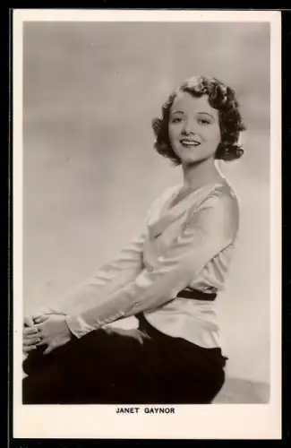 AK Schauspielerin Janet Gaynor sitzend in die Kamera lächelnd