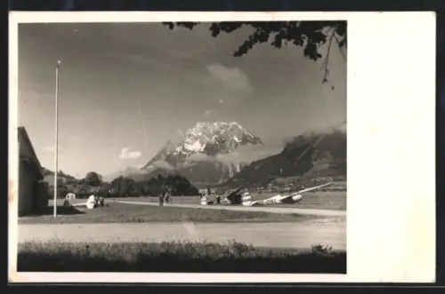 AK Aigen /Ennstal, Segelflugzeug der Alpen-Segelflugschule auf einer Wiese mit Berg im Hintergrund