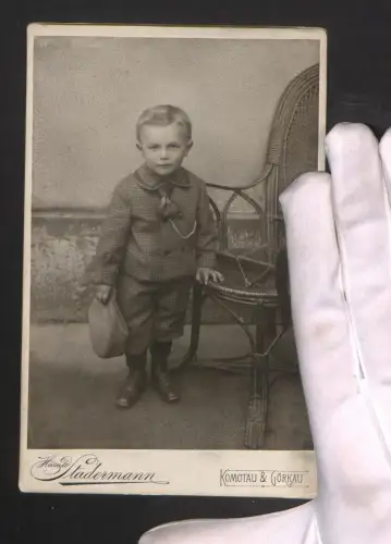 Fotografie Harald Stadermann, Komotau, Rossmarkt 428, Kleiner Junge mit Mütze steht neben einem Stuhl