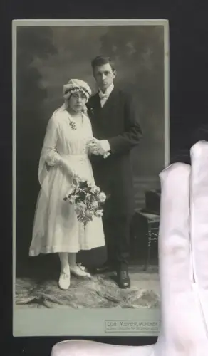 Fotografie Lorenz Meyer, München, Schellingstrasse 74, Junges Brautpaar in festlicher Kleidung mit Blumenstrauss