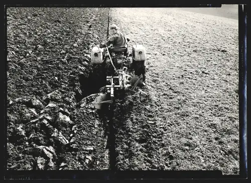 Fotografie unbekannter Fotograf und Ort, Mann fährt einen Pflug über den Acker