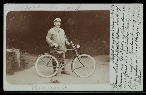 Foto-AK Mann mit Fahrrad vor einem Parkeingang