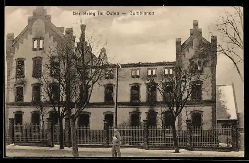 AK Gumbinnen, Der Krieg im Osten, Strassenpartie mit Gebäudeansicht und einem Soldaten
