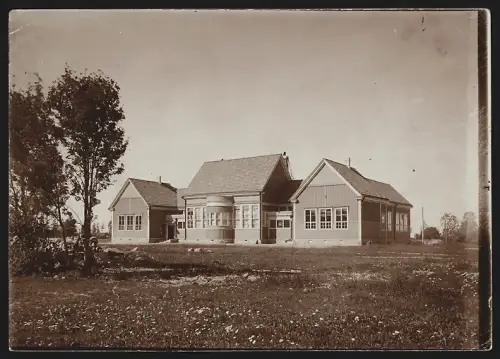 Fotografie M. L. Carstens, Hamburg, Siemsen Str. 8, Ansicht Kokkola /Gamlakarleby, Häuserkomplex mit Wiese