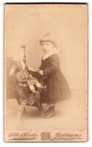 Fotografie Selle & Kuntze, Potsdam, Schwertfegerstr. 14, Mädchen hat ihre Puppe in den Sessel gesetzt