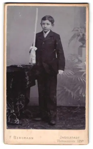 Fotografie F. Bergmann, Ingolstadt, Theresienstr. 329, Knabe mit Kerze im Anzug zur Kommunion