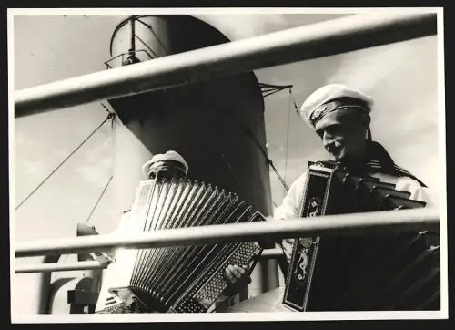 Fotografie Matrosen mit Akkordeon spielen an Deck eines Dampfers