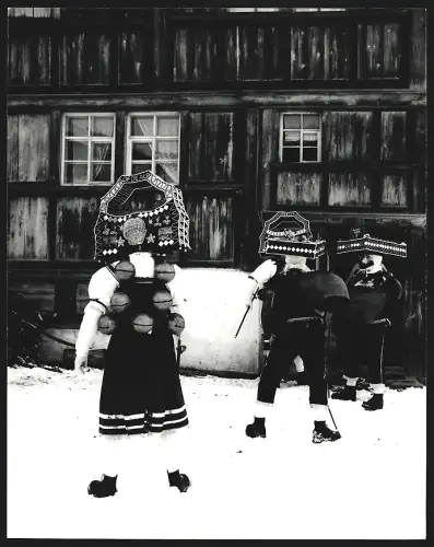 Fotografie Ansicht Urnäsch, Silvesterklausen, Drei Personen in traditionellen Kostümen vor einem Haus