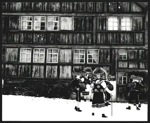 Fotografie Ansicht Urnäsch, Silvesterklausen, Gruppe in traditionellen Kostümen steht vor einem Wohnhaus