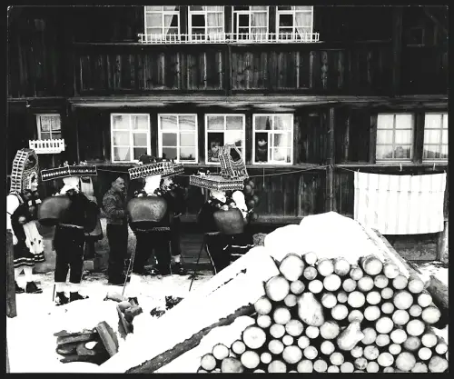 Fotografie Ansicht Urnäsch, Silvesterklausen, Gruppe in traditionellen Kostümen im Schnee vor einem Haus