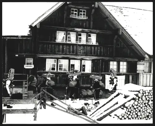 Fotografie Ansicht Urnäsch, Silvesterklausen, Gruppe in traditionellen Kostümen im Schnee, spiegelverkehrter Abzug