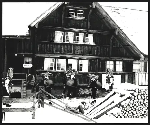 Fotografie Ansicht Urnäsch, Silvesterklausen, Gruppe in traditionellen Kostümen vor einem Haus, spiegelverkehrter Abzug