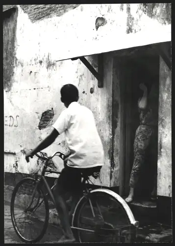 Fotografie Hermann Engel, Köln-Klettenberg, Weinhausstr. 36, Malaysia, Mann fährt auf einem Fahrrad an einem Haus vorbei