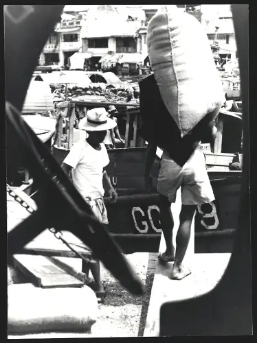 Fotografie Hermann Engel, Köln-Klettenberg, Weinhausstr. 36, Malaysia, Person trägt grossen Sack zu einem Boot