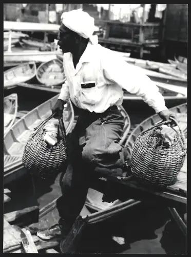 Fotografie Hermann Engel, Köln-Klettenberg, Weinhausstr. 36, Malaysia, Mann steigt mit zwei Körben aus einem Boot