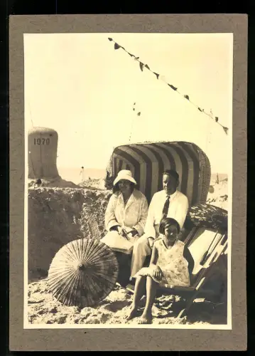 Fotografie Familie in Badekleidung sitzt an einem sonnigen Tag in einem Strandkorb