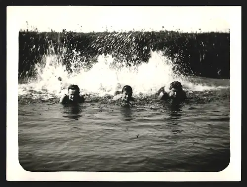 Fotografie Drei Menschen in Badebekleidung beim Schwimmen