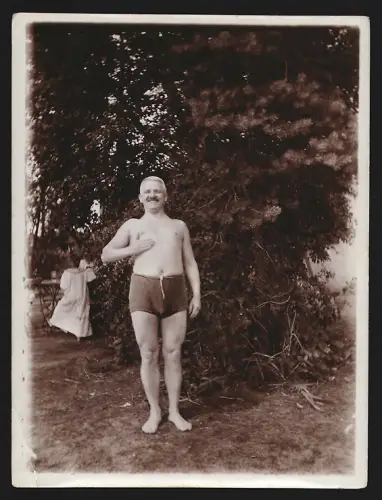 Fotografie Älterer Mann in Badehose steht im Jahr 1917 bei einem Baum