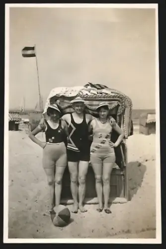 Fotografie Mann und zwei Frauen in Badeanzügen vor einem Strandkorb im Jahr 1931