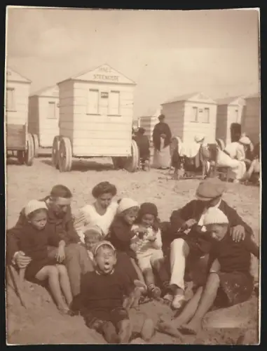 Fotografie Familien und Kinder sitzen am Strand im Sand