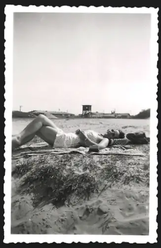 Fotografie Frau im Badeanzug liegt am Strand in der Sonne