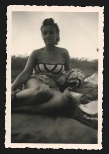 Fotografie Frau im Bikini liegt auf einer Decke auf einer Wiese