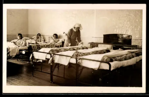 Foto-AK Krankenschwester kümmert sich um Neugeborene die gemeinsam in Betten liegen